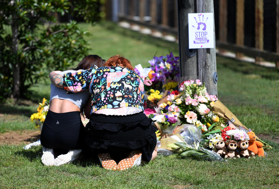 Mourners hug at the makeshift shrine near the scene of the tragedy at Camp Hill. Source: AAP