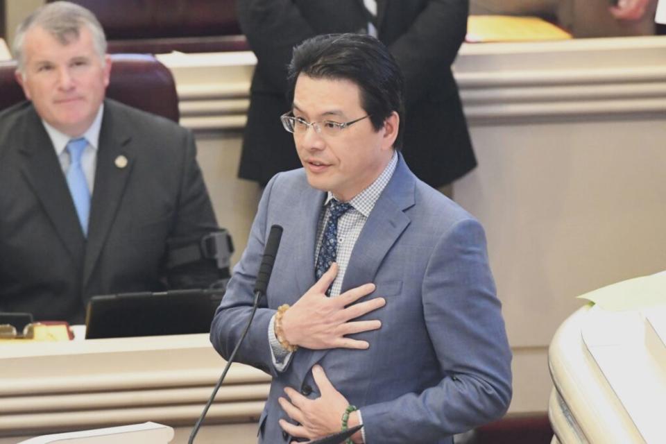 A man in a suit with his hand over his chest