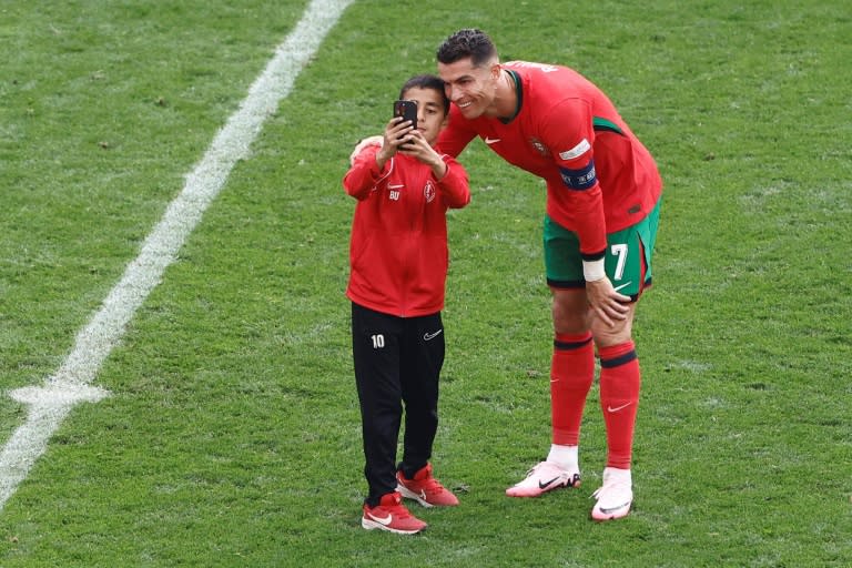 A young pitch invader takes a selfie with <a class="link " href="https://sports.yahoo.com/soccer/players/3903793/" data-i13n="sec:content-canvas;subsec:anchor_text;elm:context_link" data-ylk="slk:Cristiano Ronaldo;sec:content-canvas;subsec:anchor_text;elm:context_link;itc:0">Cristiano Ronaldo</a> during Saturday's Euro 2024 match between <a class="link " href="https://sports.yahoo.com/soccer/teams/portugal/" data-i13n="sec:content-canvas;subsec:anchor_text;elm:context_link" data-ylk="slk:Portugal;sec:content-canvas;subsec:anchor_text;elm:context_link;itc:0">Portugal</a> and Turkey in <a class="link " href="https://sports.yahoo.com/soccer/teams/dortmund/" data-i13n="sec:content-canvas;subsec:anchor_text;elm:context_link" data-ylk="slk:Dortmund;sec:content-canvas;subsec:anchor_text;elm:context_link;itc:0">Dortmund</a> (KENZO TRIBOUILLARD)