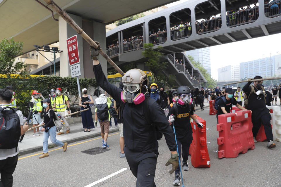 A demonstrator carries a bamboo pole during a protest in Hong Kong, Saturday, Aug. 24, 2019. Chinese police said Saturday they released an employee at the British Consulate in Hong Kong as the city's pro-democracy protesters took to the streets again, this time to call for the removal of "smart lampposts" that raised fears of stepped-up surveillance. (AP Photo/Kin Cheung)