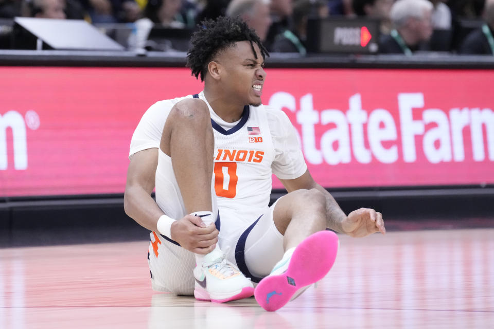 Illinois's Terrence Shannon Jr. holds his ankle during the second half of an NCAA college basketball game against Penn State at the Big Ten men's tournament, Thursday, March 9, 2023, in Chicago. Penn State won 79-76. (AP Photo/Charles Rex Arbogast)