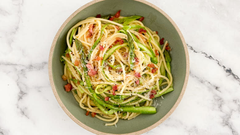 spaghetti carbonara with asparagus in bowl