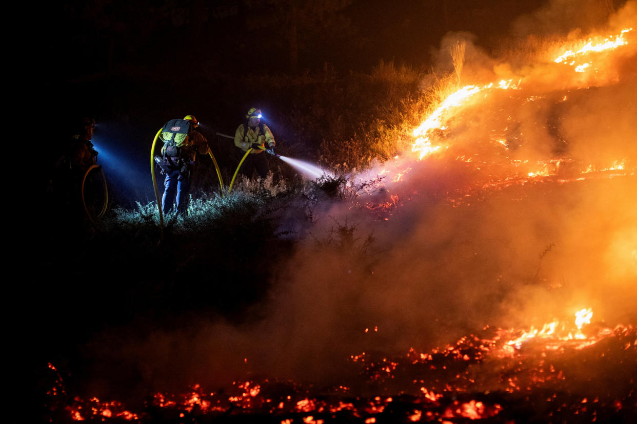 Cal Fire firefighters tackle the Bridge Fire, which is threatening mountain communities to the northeast of Los Angeles, in Wrightwood, Calif., on Wednesday.