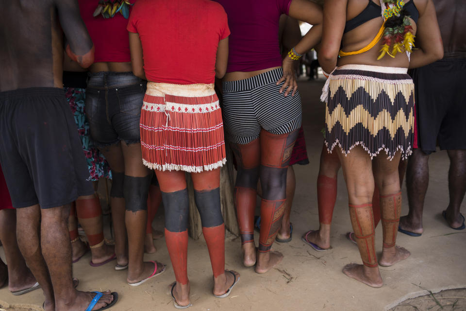 In this Sept. 3, 2019 photo, Tembé Indians painted with with red dye from urucum seeds from the Amazon rainforest listen to speakers during a meeting of tribes at the Tekohaw indigenous reserve, Para state, Brazil. Some had travelled long distances on dirt roads that cut through the lush jungle, or in boats along a muddy brown tributary of the Amazon River. (AP Photo/Rodrigo Abd)