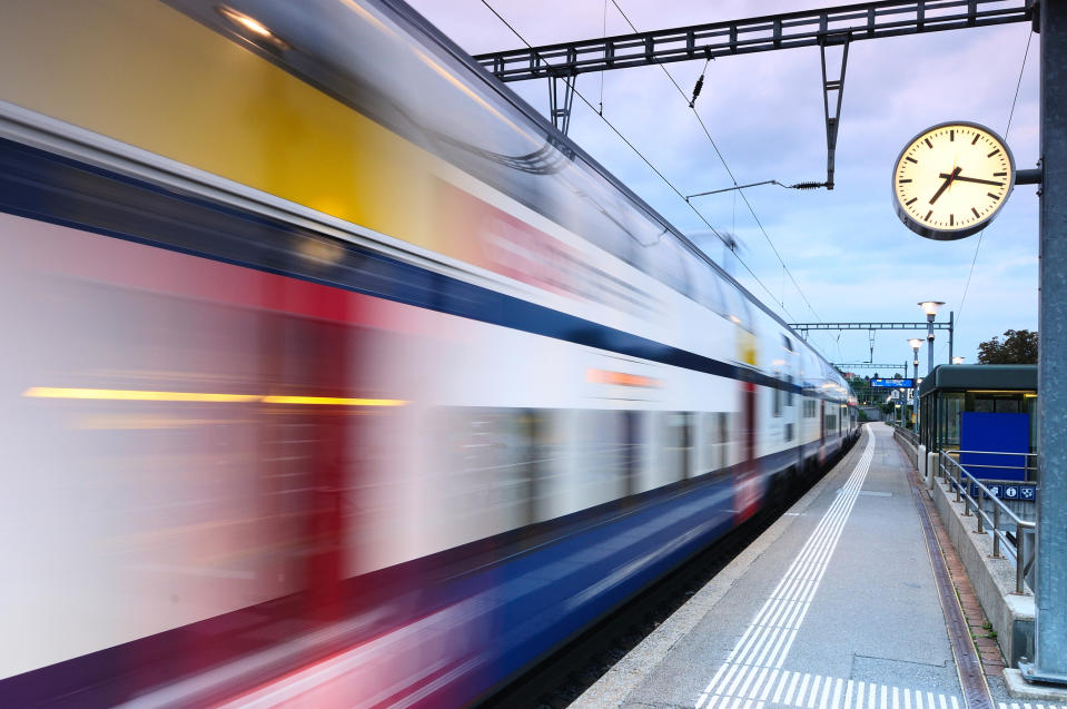 A transit train in motion at a station.