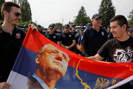 Supporters of Serbian Radical Party leader Vojislav Seselj hold banners in front of police officers during a protest in the village of Jarak, near Hrtkovci, Serbia, May 6, 2018. REUTERS/Marko Djurica