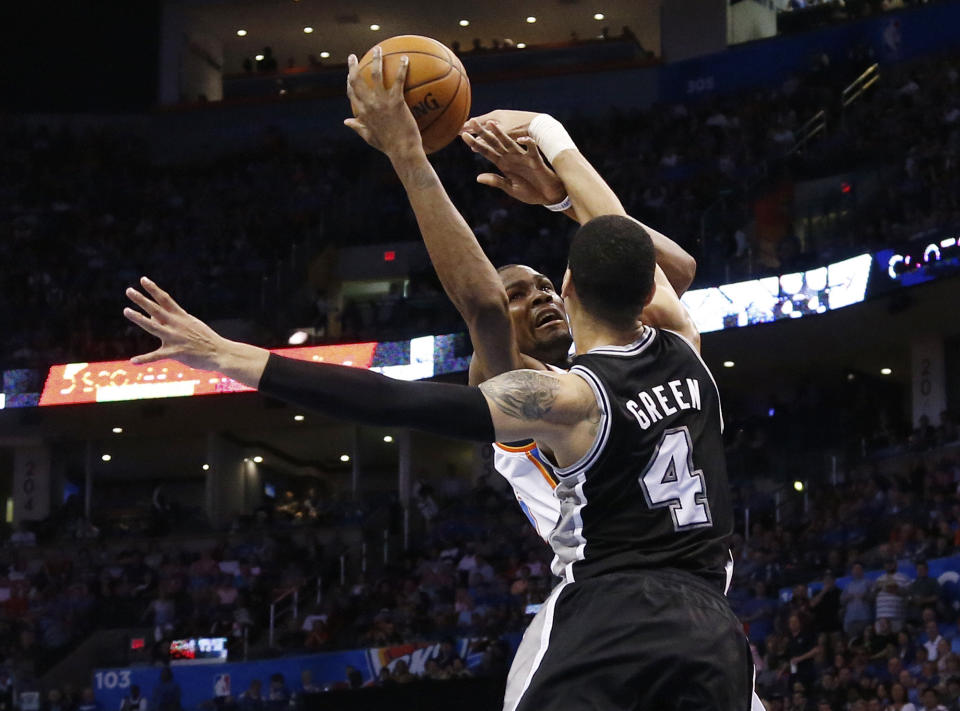 Oklahoma City Thunder forward Kevin Durant (35) is fouled by San Antonio Spurs guard Danny Green (4) on a shot during the second quarter of an NBA basketball game in Oklahoma City, Thursday, April 3, 2014. (AP Photo/Sue Ogrocki)