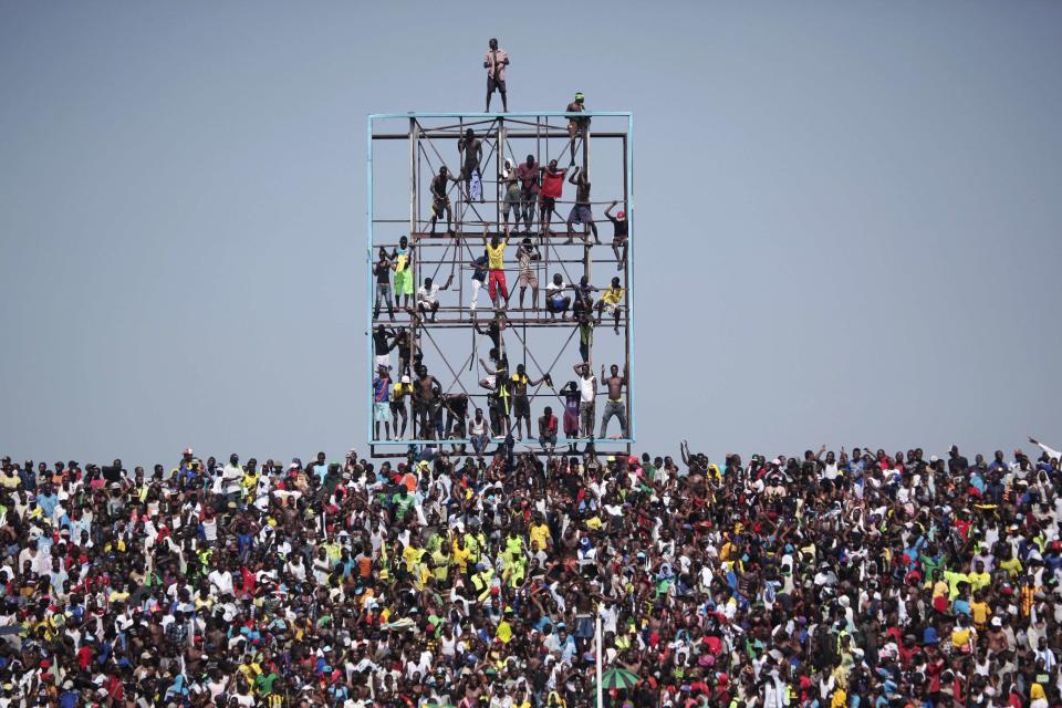 Fans climb a scoreboard to watch an African Cup of Nations qualifying soccer match between Ivory Coast and Democratic Republic of Congo in Kinshasa , in this October 11, 2014 file photo. REUTERS/Media Coulibaly/Files (DEMOCRATIC REPUBLIC CONGO - Tags: TPX IMAGES OF THE DAY SPORT SOCCER)