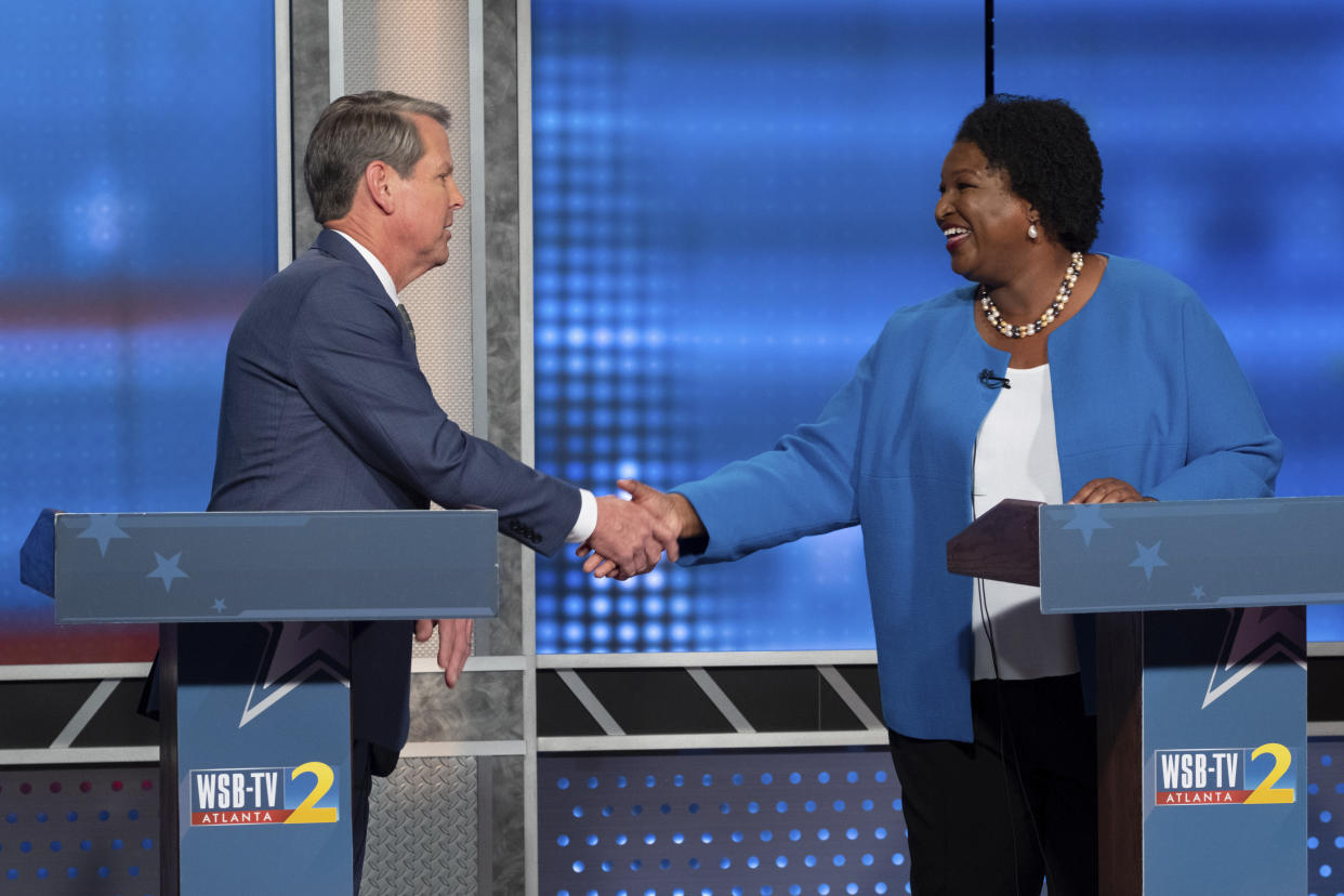 Republican Georgia Gov. Brian Kemp, left, shakes hands with Democratic challenger Stacey Abrams following a televised debate, in Atlanta, Sunday, Oct. 30, 2022. (AP Photo/Ben Gray)