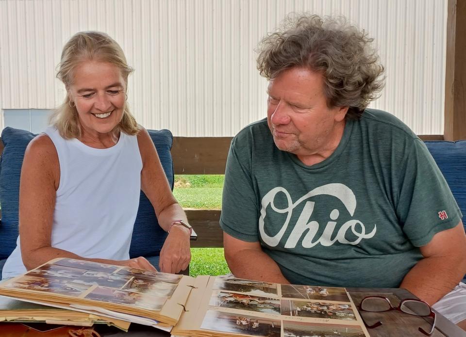 Tammy Simone and Lakewood Racquet Club pro Ron Schaub look at some of her old scrapbooks.