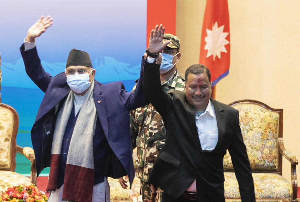 Nepalese Prime Minister Khadga Prassad Oli, left, and leader of Nepal Communist Party group Netra Bikram Chand raise their hands during a signing of peace agreement in Kathmandu, Nepal, Friday, March 5, 2021. Chand, who is better known by his guerrilla name Biplav, emerged out of hiding on Friday after the government lifted a ban on his group so it could take part in the public signing of the peace agreement. This group had split from the Maoist Communist party, which fought government troops between 1996 and 2006, when it gave up its armed revolt, agreed to U.N.-monitored peace talks and joined mainstream politics. (AP Photo/Niranjan Shrestha)