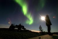 KANGERLUSSUAQ, GREENLAND - SEPTEMBER 02: (ISRAEL OUT) Tourists admire The Aurora Borealis as it glows in the sky September 02, 2007, near the Greenland town of Kangerlussuaq. The Northern Lights most often occurs from September to October and from March to April and are a popular tourist attraction. (Photo by Uriel Sinai/Getty Images)