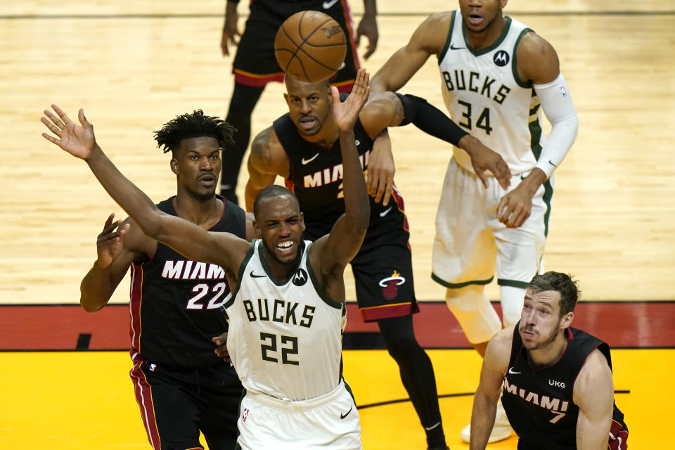 Milwaukee Bucks forward Khris Middleton (22) loses control of the ball as Miami Heat forward Jimmy Butler (22) and guard Goran Dragic (7) defend during the second half of Game 4 of an NBA basketball first-round playoff series, Saturday, May 29, 2021, in Miami. (AP Photo/Lynne Sladky)