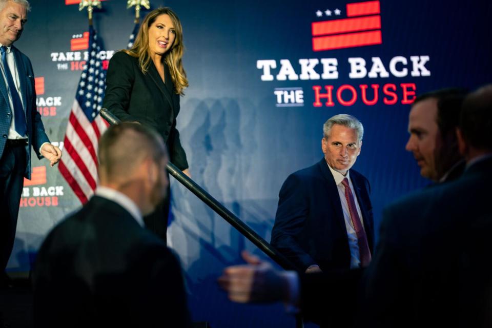 A man walks down stairs among other people near a logo that says Take Back the House.