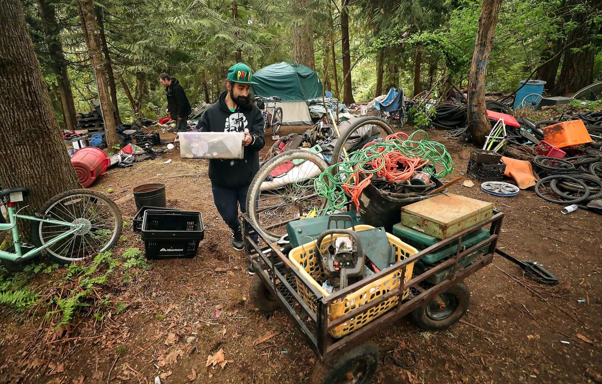 Anthony (no last name given) helps load belongings into a cart as his friends move out of their campsite in Veterans Memorial Park in Port Orchard on Friday, April 29, 2022. Anthony used to live in Veterans Memorial Park but found somewhere else to live recently and came back to help his friends that were being evicted from the park.
