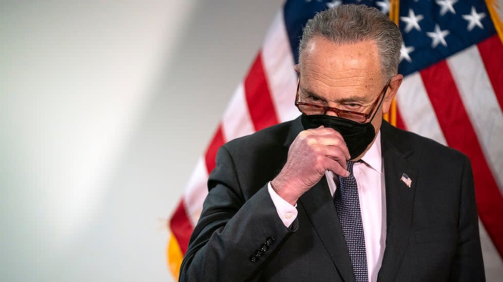 Majority Leader Charles Schumer (D-N.Y.) adjusts his mask  during a press conference following the weekly policy luncheon on Tuesday, February 1, 2022.