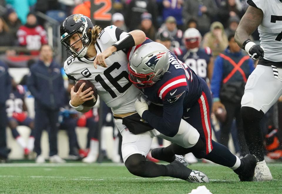 Jacksonville Jaguars quarterback Trevor Lawrence (16) is sacked by New England Patriots defensive end Christian Barmore (90).