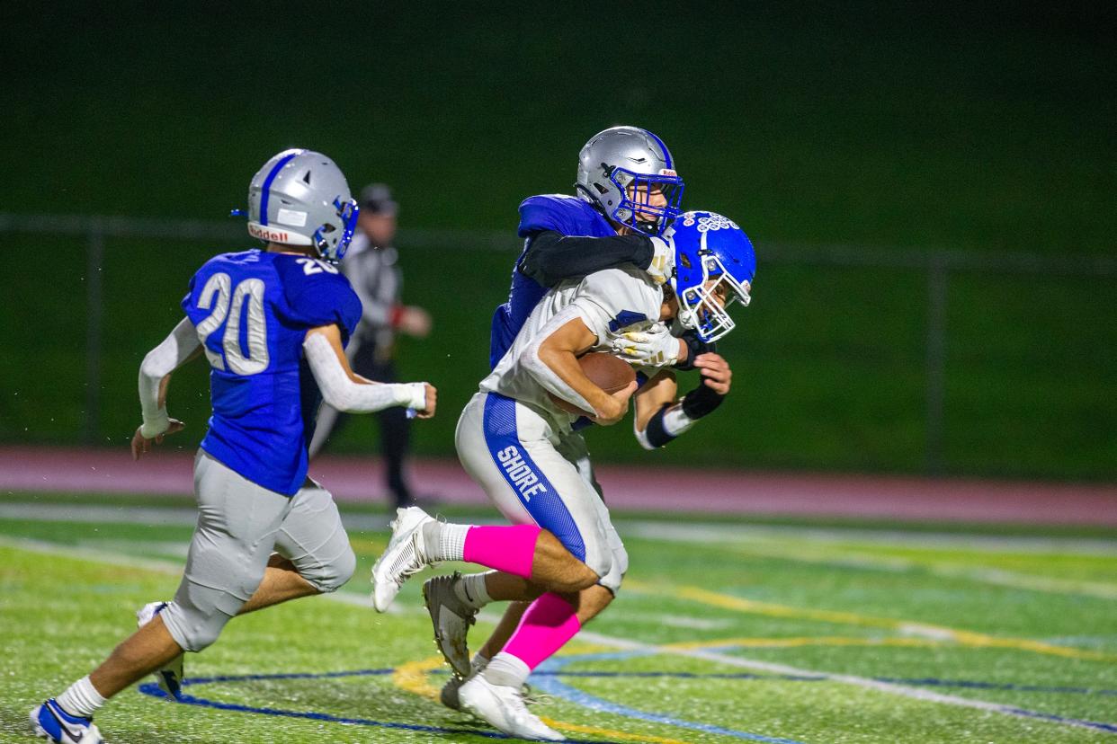 Shore Regional's Alex George catches a pass and is tackled by Holmdel's Gary Collyer during the Shore Regional vs. Holmdel football game at Holmdel High School in Holmdel, NJ Friday, October 20, 2023.