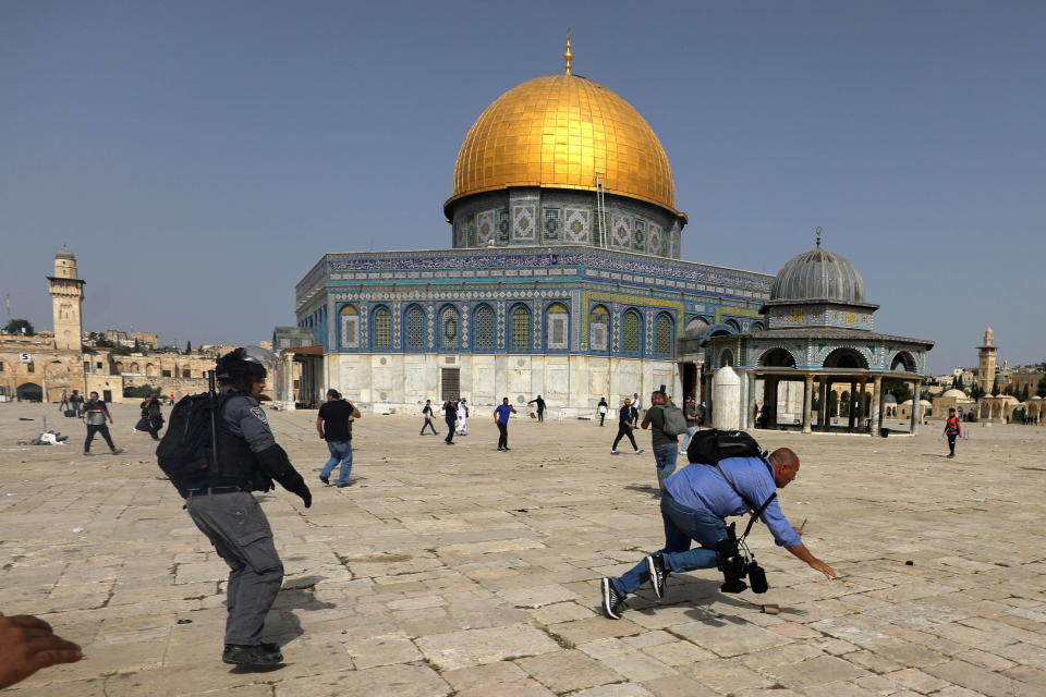 A camera operator falls as an Israeli police officer runs after him during clashes with Palestinians at the compound that houses al-Aqsa Mosque, known to Muslims as Noble Sanctuary and to Jews as Temple Mount, in Jerusalem's Old City on May 10, 2021. / Credit: AMMAR AWAD/REUTERS