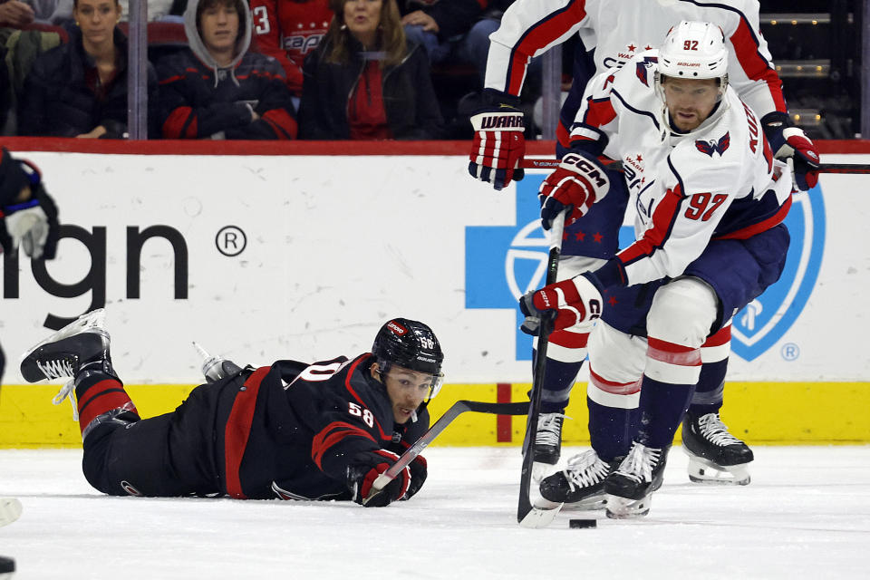 Washington Capitals' Evgeny Kuznetsov (92) controls the puck after he takes it away from Carolina Hurricanes' Michael Bunting (58) during the first period of an NHL hockey game in Raleigh, N.C., Sunday, Dec. 17, 2023. (AP Photo/Karl B DeBlaker)