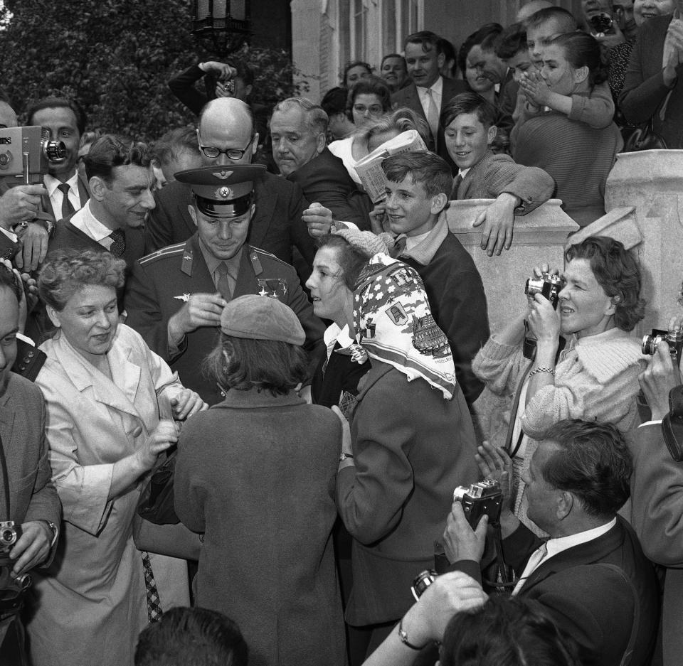 FILE - In this Saturday, July 15, 1961 file photo, autograph hunters jostle round Major Yuri Gagarin, the Russian cosmonaut, at the Soviet Embassy in London, as he left for London airport after his visit to Britain in connection with the soviet exhibition in London. The successful one-orbit flight on April 12, 1961 made the 27-year-old Gagarin a national hero and cemented Soviet supremacy in space until the United States put a man on the moon more than eight years later. (AP Photo/Dennis Lee Royle, File)