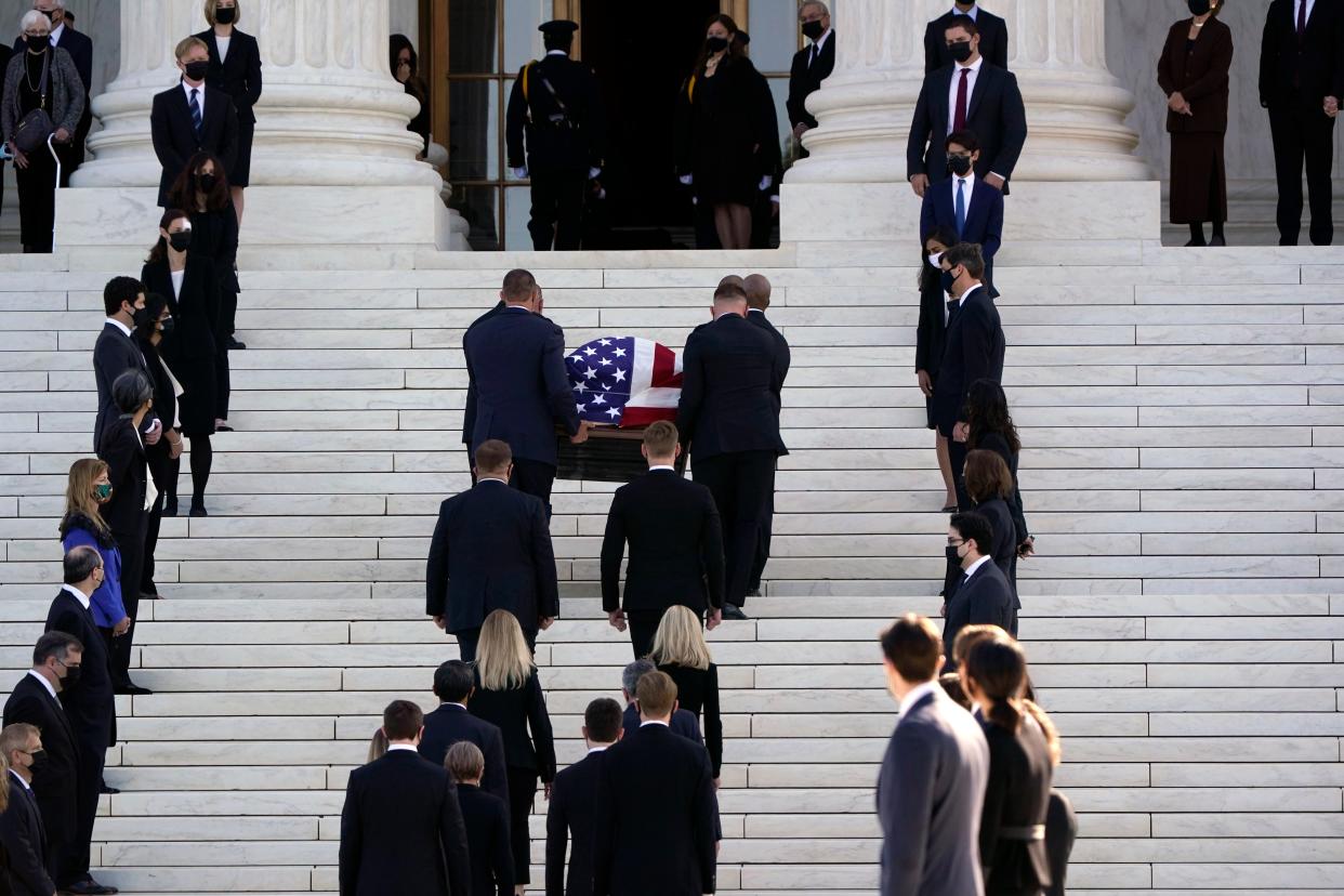 Just over one hundred former law clerks gather to honour Ruth Bader Ginsburg as her coffin is carried to the Supreme Court (AP)