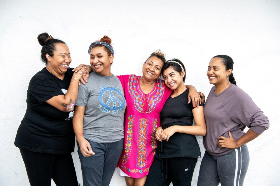 A family portrait of a mother surrounded by four of her daughters.