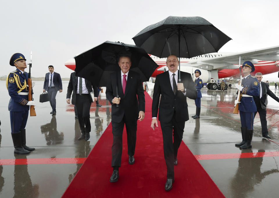 In this handout photo released by Turkish Presidency, Azerbaijan's President Ilham Aliyev, right, welcomes Turkey's President Recep Tayyip Erdogan in Nakhchivan, Azerbaijan, Monday, Sept. 25, 2023. Thousands of Armenians streamed out of Nagorno-Karabakh after the Azerbaijani military reclaimed full control of the breakaway region while Turkish President Recep Tayyip Erdogan visited Azerbaijan Monday in a show of support to its ally. (Turkish Presidency via AP)