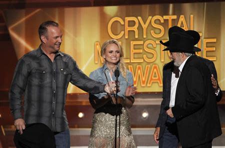 Garth Brooks (L), Miranda Lambert and George Strait (obscured) present the Crystal Milestone Award to Merle Haggard (R) at the 49th Annual Academy of Country Music Awards in Las Vegas, Nevada April 6, 2014. REUTERS/Robert Galbraith