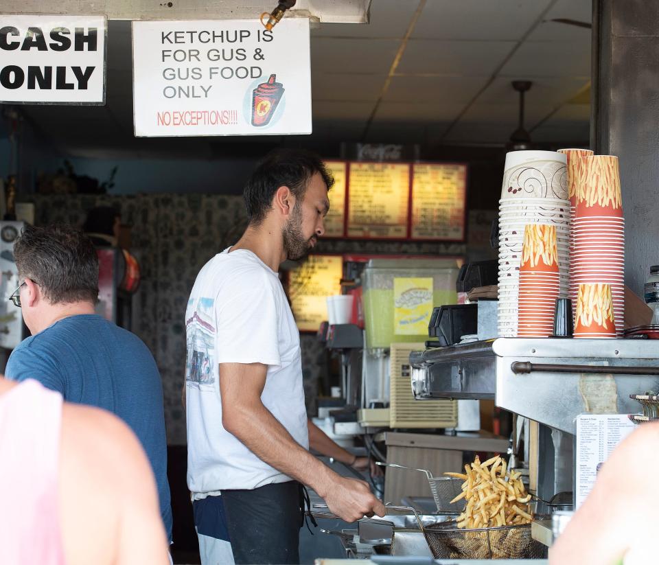 Abrorjon Abdulazimov prepares fries at Gus & Gus in Rehoboth Beach.