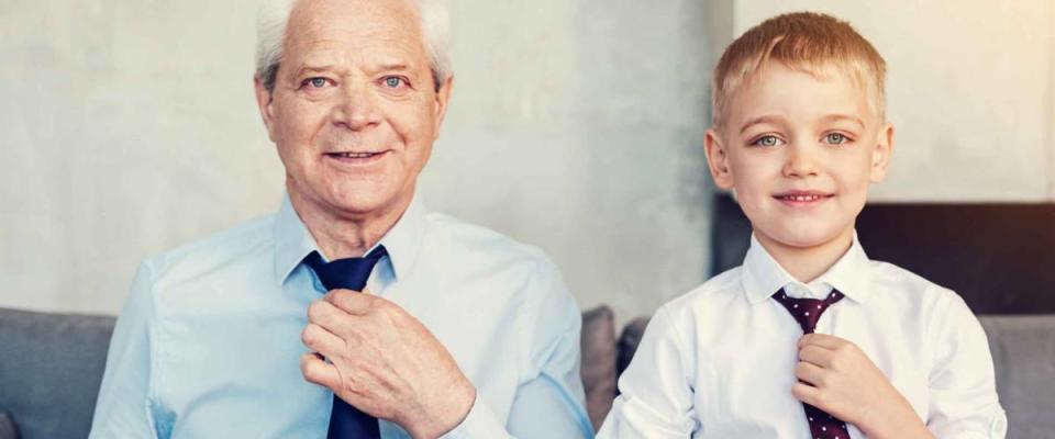 Handsome men. Happy friendly stylish grandfather and his little cheerful grandson wearing fashionable ties before going out