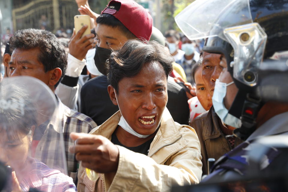 A man gestures with his hand while talking to riot police about recent arrests made in Mandalay, Myanmar Saturday, Feb. 13, 2021. Daily rallies against the coup occurring in Myanmar's two largest cities, Yangon and Mandalay, enter its second week despite a ban on public gatherings of five or more.(AP Photo)