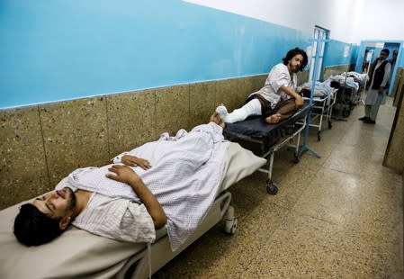 Injured men receive treatment in the hospital after sustaining wounds from a blast at a wedding hall in Kabul, Afghanistan