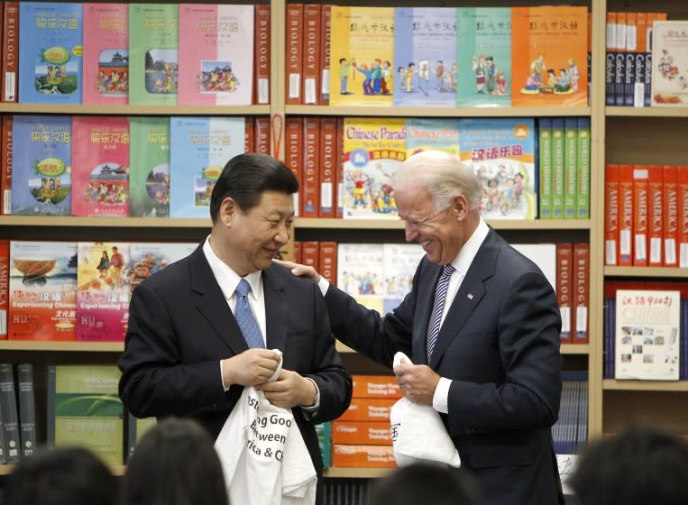 Chinese Vice President Xi Jinping and Vice President Joe Biden hold t-shirts given to them by students at the International Studies Learning Center in South Gate, Calif. , Friday, Feb. 17, 2012. (AP Photo/Damian Dovarganes)