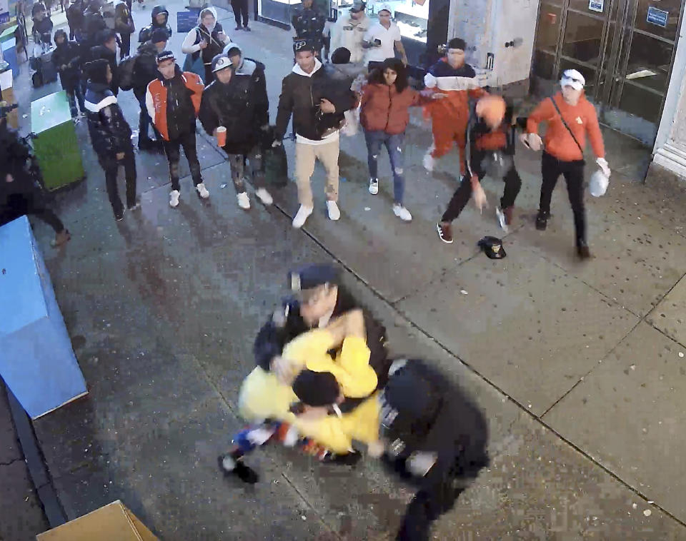 This image from video provided by the Office of the Manhattan District Attorney, Thursday, Feb. 8, 2024, shows the brawl between New York City Police Department officers and migrants in Times Square, Jan. 27, 2024. Manhattan D.A. Alvin Bragg announced six additional indictments of men allegedly involved in a brawl with police officers in Times Square, but he said investigators were still working to identify several suspects and their exact role in the frenzy. (Manhattan District Attorney via AP)