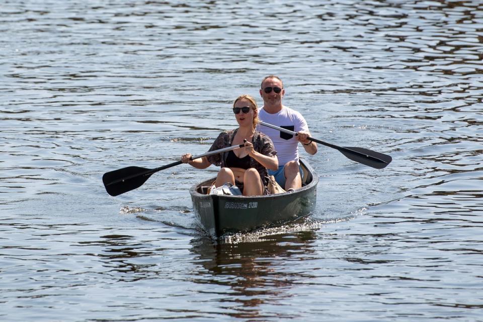 A couple takes a paddle along the Norfolk Broads, the site of one of England's 10 national parks (PA)