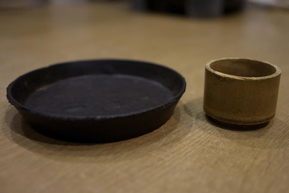 A plate and cup made from food cement are seen at the laboratory of Tokyo University in Tokyo on May 26, 2022. The university's researchers Kota Machida and Yuya Sakai have developed a technology that can transform food waste into “cement" for construction use. (AP Photo/Chisato Tanaka)