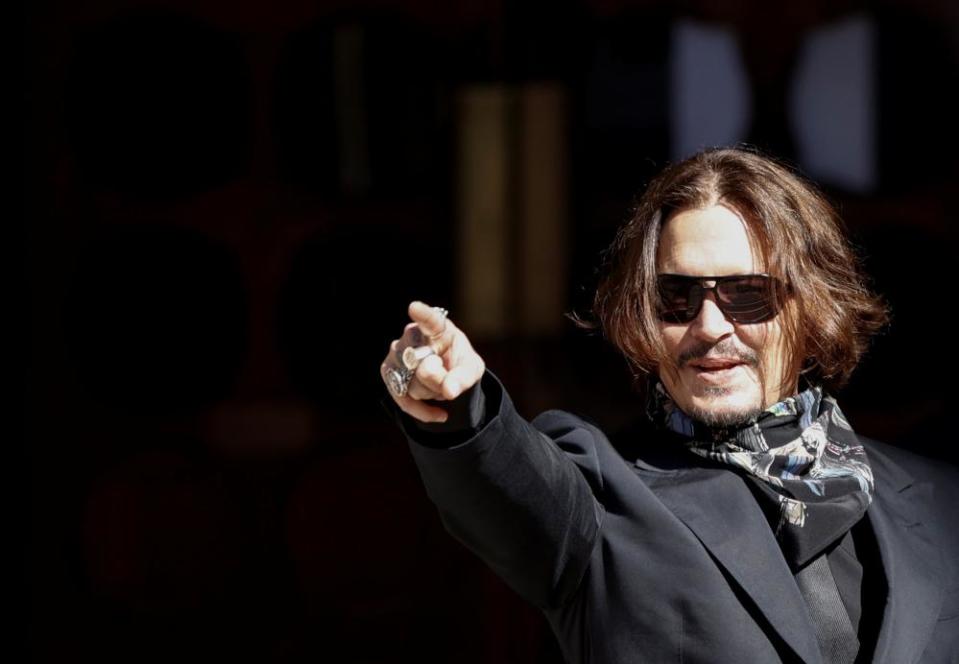 Johnny Depp gestures as he arrives at the High Court