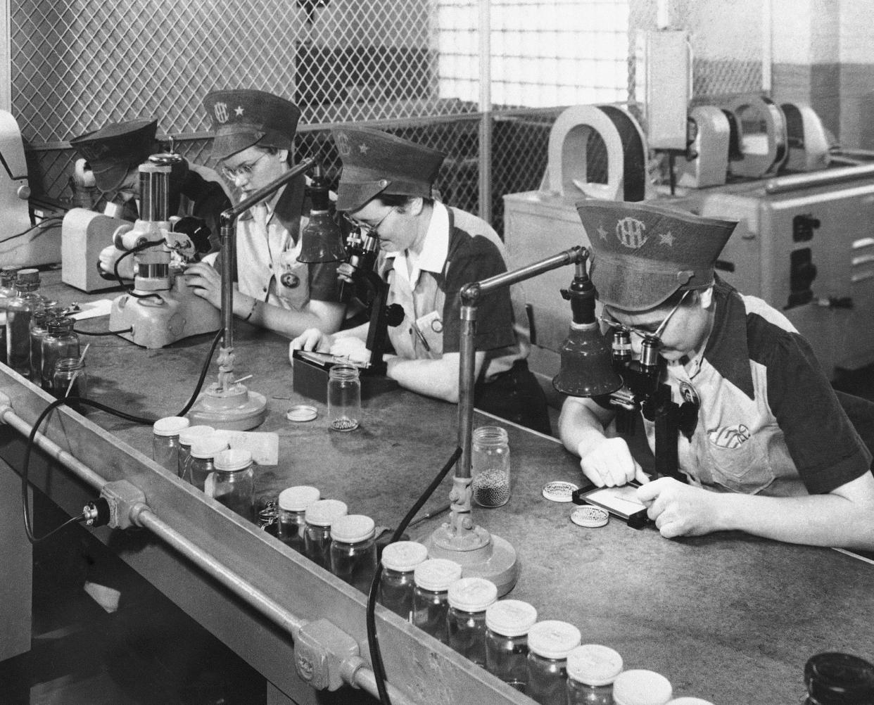 In this Feb. 10, 1943, file photo, employees of International Harvester inspect ball bearings in Chicago, the smallest being one-eighth of an inch in diameter. The bearings must be sorted according to size within 25 millionths of an inch. Not since World War II when factories converted from making automobiles to making tanks, Jeeps and torpedos has the entire nation been asked to truly sacrifice for a greater good.