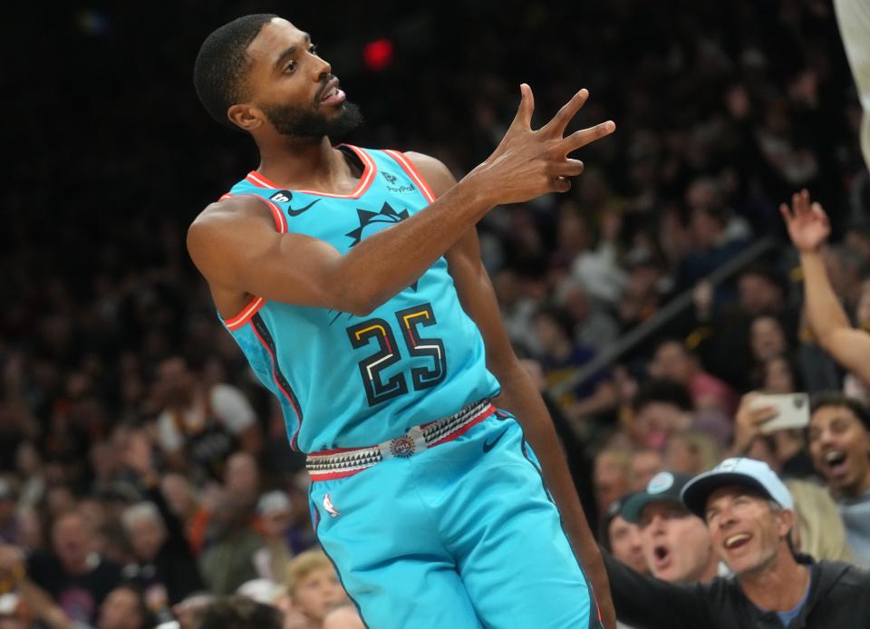 Nov 16, 2022; Phoenix, AZ, USA; Phoenix Suns forward 	Mikal Bridges (25) signals to the crowd after making a 3-pointer against the Golden State Warriors at Footprint Center.