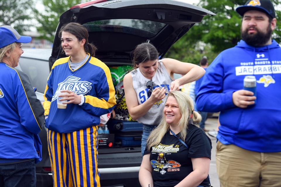 Maddie Mack braids Matty Kerr's hair during a tailgate on Sunday, May 16, 2021 outside Toyota Stadium in Frisco, Texas.