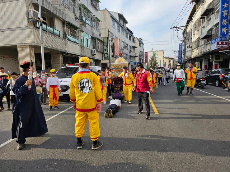 大馬路上民眾聚集等候鑽轎底，秩序良好跪趴於地。（記者湯茗富攝）