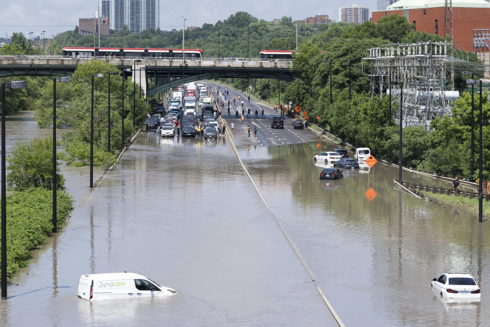 Cars are partially submerged in flood waters in the Don Valley following heavy rain in Toronto, on Tuesday, July 16 2024. THE CANADIAN PRESS/Arlyn McAdorey