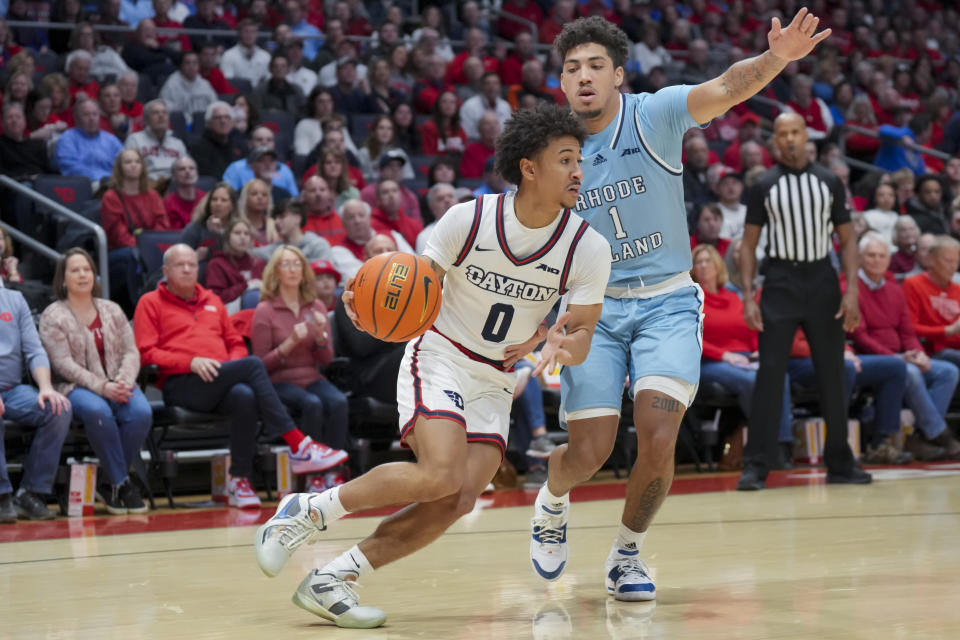 Dayton guard Javon Bennett (0) dribbles the ball around Rhode Island guard Luis Kortright (1) during the first half of an NCAA college basketball game, Saturday, Jan. 20, 2024, in Dayton, Ohio. (AP Photo/Aaron Doster)