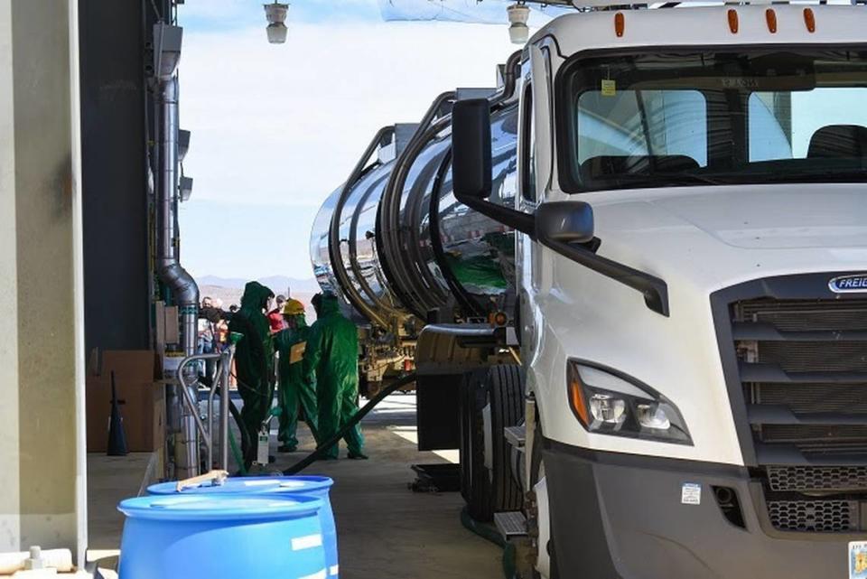 Workers unload a tanker truck carrying sodium hydroxide, a simulant for tank waste, at the Hanford Waste Treatment Plant. The chemical will be used to test treatment processes before radioactive waste is used.