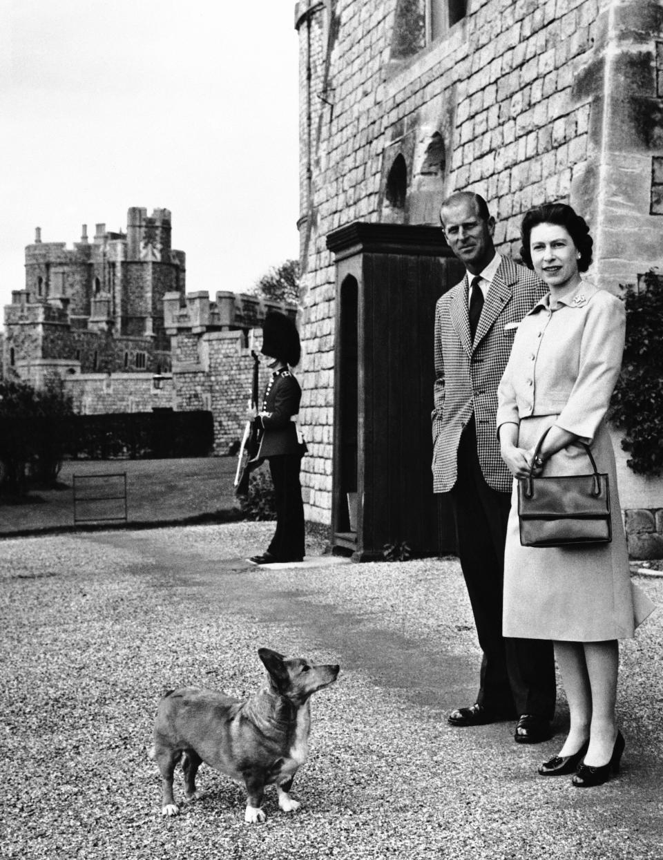 FILE - Queen Elizabeth II and Prince Philip strolled near the George IV gateway of Britain's Windsor Castle on June 2, 1959. Queen Elizabeth II's corgis were a key part of her public persona and her death has raised concern over who will care for her beloved dogs. The corgis were always by her side and lived a life of privilege fit for a royal. She owned nearly 30 throughout her life. She is reportedly survived by four dogs. (AP Photo)