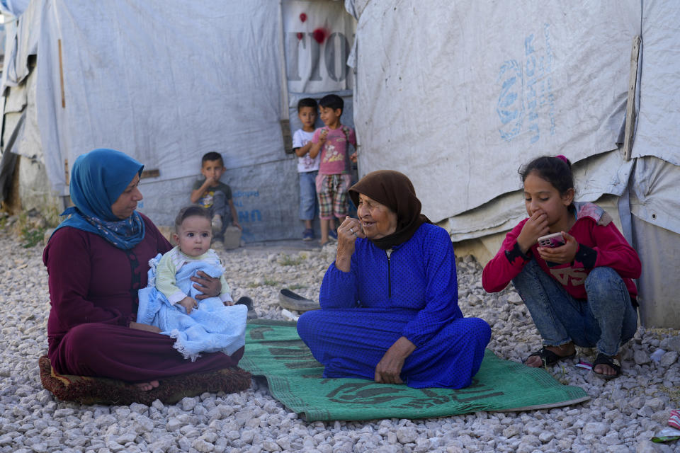 A Syrian family sits in front of their tent at a refugee camp in the town of Bar Elias, in Lebanon's Bekaa Valley, Tuesday, June 13, 2023. Aid agencies are yet again struggling to draw the world's attention back to Syria in a two-day donor conference hosted by the European Union in Brussels for humanitarian aid to Syrians that begins Wednesday. Funding from the conference also goes toward providing aid to some 5.7 million Syrian refugees living in neighboring countries, particularly Turkey, Lebanon and Jordan. (AP Photo/Bilal Hussein)