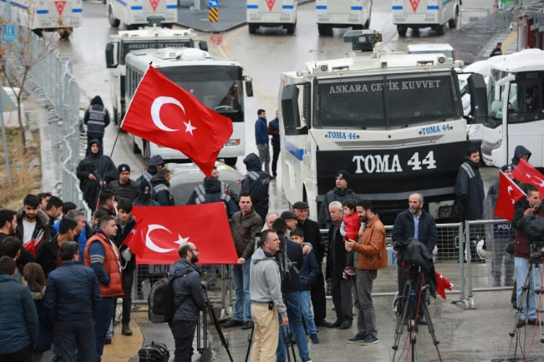 Demonstrators wave the Turkish national flag by a blockade of anti-riot police vehicles and a sealed off area surrounding the Dutch embassy in Ankara on March 12, 2017