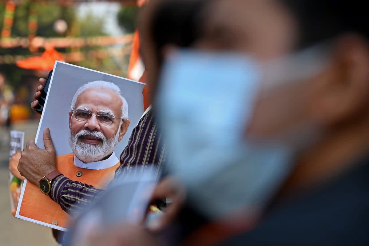 File. A supporter of the Bharatiya Janata Party (BJP) holds a picture of India's Prime Minister Narendra Modi during a roadshow ahead of the BJP national executive meet in New Delhi on 16 January 2023 (AFP via Getty Images)