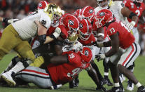 The Georgia defense led by defensive lineman Jordan Davis, bottom, who arrived first, smothers Notre Dame running back Tony Jones Jr. during the third quarter of an NCAA college football game Saturday, Sept. 21, 2019, in Athens, Ga. (Curtis Compton/Atlanta Journal Constitution via AP)